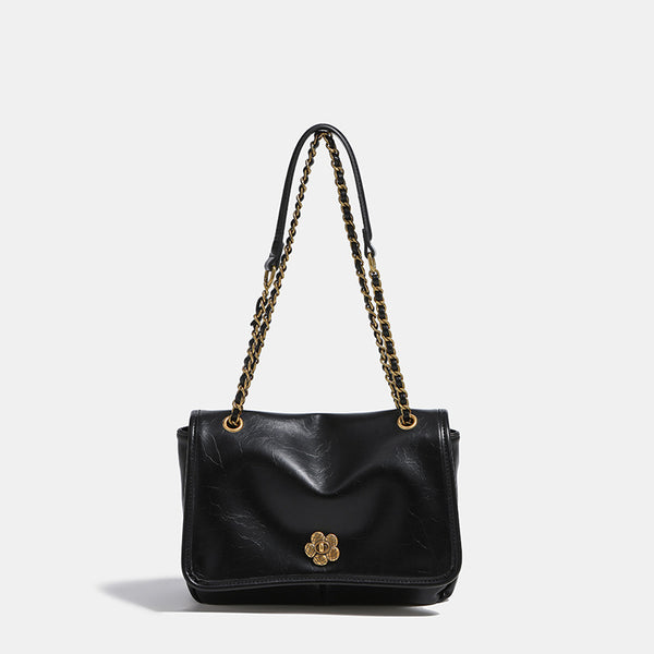 Structured flap shoulder bag with antique gold-tone chain strap and flower turn-lock clasp in crinkled leather-look finish
