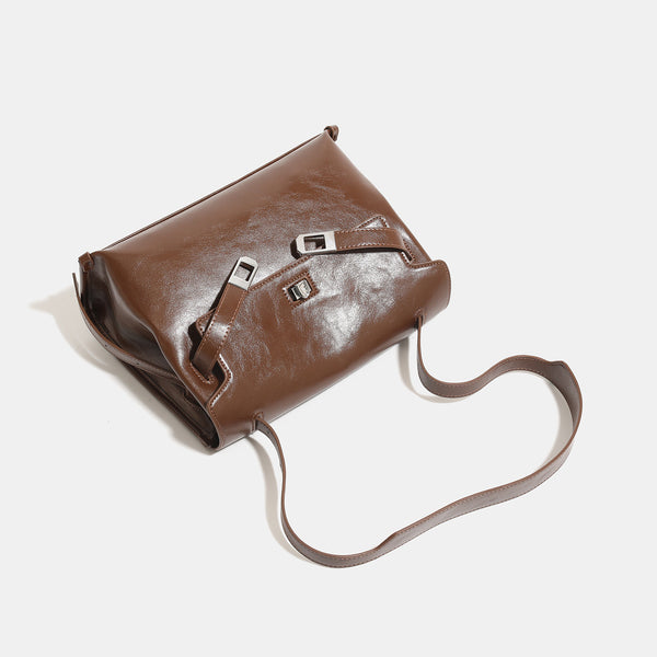 Structured rectangular flap shoulder bag in glossy leather-look finish with silver turn-lock clasp and adjustable strap