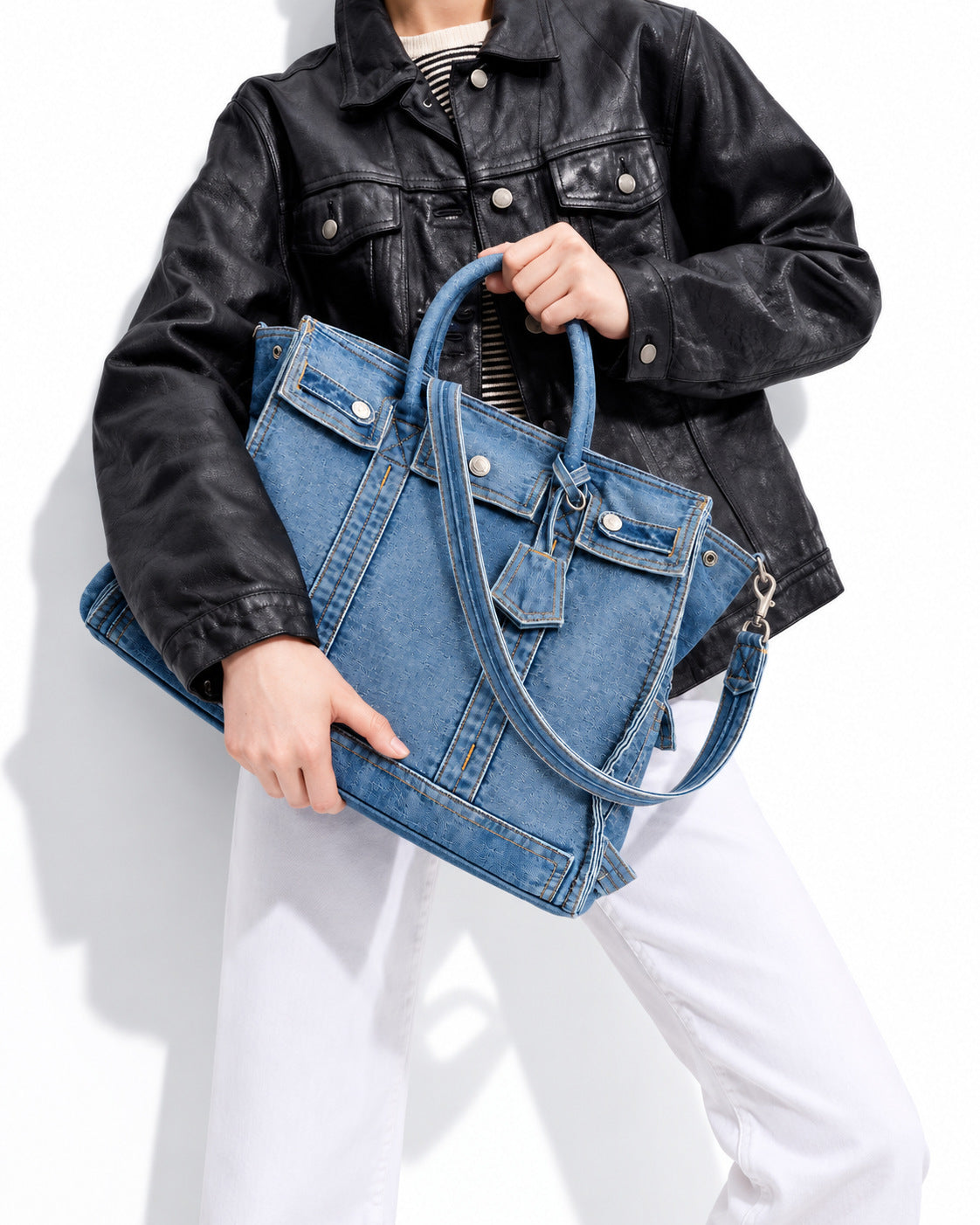 Large washed denim patchwork tote bag with snap-flap front pockets, rolled handles, and detachable shoulder strap, detail