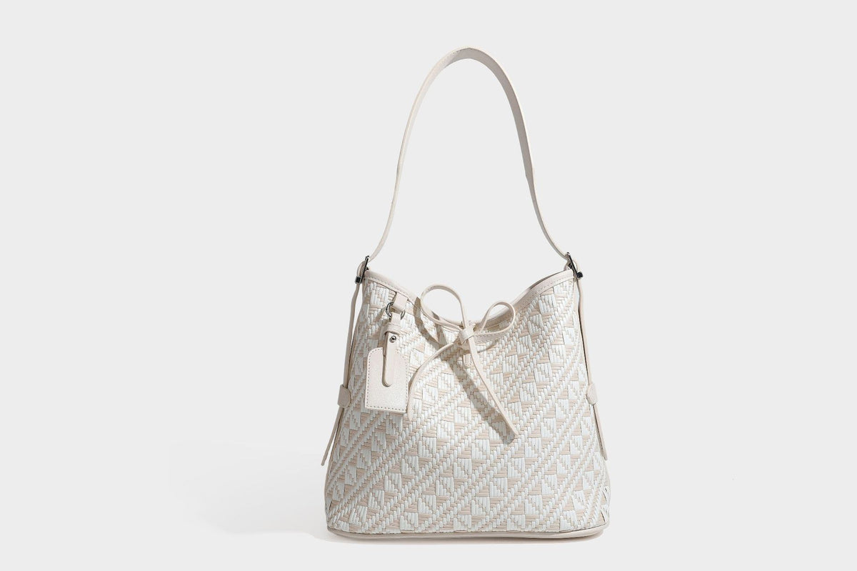 Woven geometric bucket shoulder bag in white and dark brown two-tone pattern with leather-look trim and drawstring top