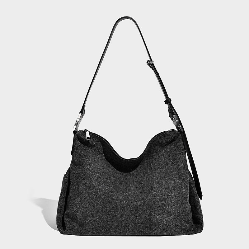Charcoal denim-textured slouchy hobo bag with zip-top closure, silver-tone hardware, and adjustable leather-look crossbody