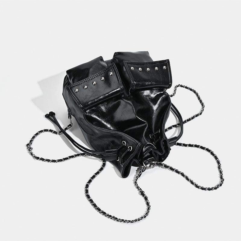 Glossy leather-look drawstring bucket bag with silver dome studs and chain shoulder strap, detail view 4