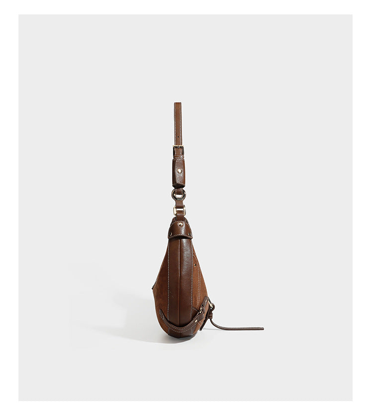 Halbmondförmige Schultertasche in hellbrauner Velourslederoptik mit weißen Kontrastnähten, goldfarbenen Schnallen und