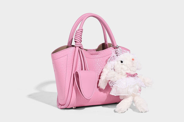 Structured mini tote bag in pebbled leather-look finish with knotted top handles, front flap pocket, and detachable shoulder