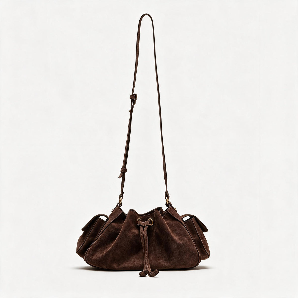 Weiche Beuteltasche mit Kordelzug in Taupe und Wildlederoptik, seitlichen Klappentaschen, antikgoldfarbenen Metalldetails und verstellbarem Crossbody-Riemen