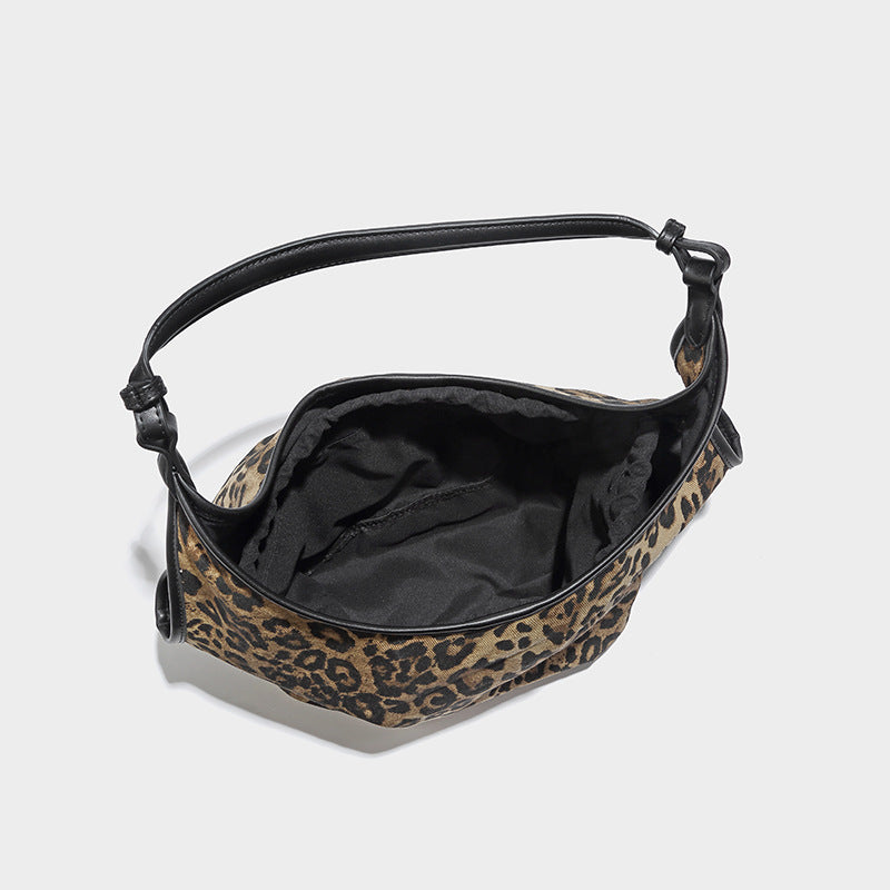 Slouchy brown leopard jacquard hobo tote bag with black leather-look trim and single shoulder strap, shown with black, detail