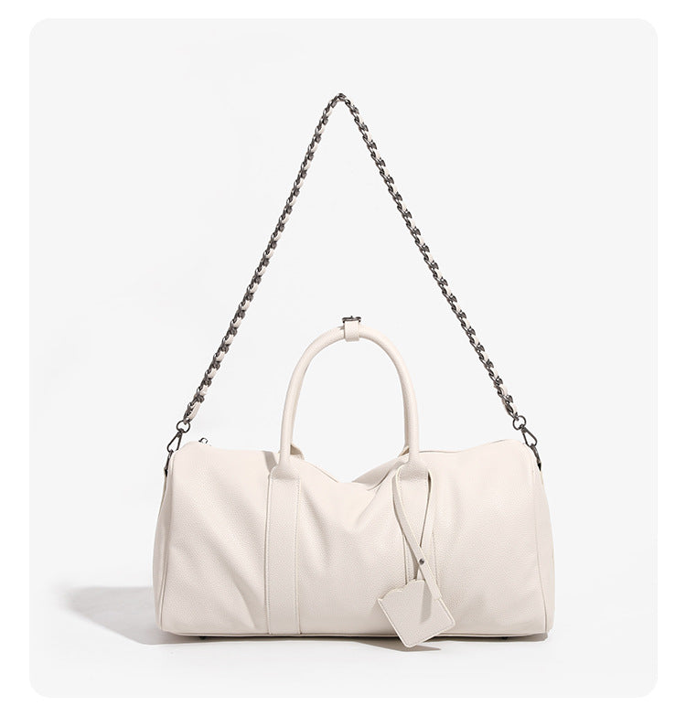 Large cream white pebbled leather-look barrel travel bag with twin top handles, chunky chain shoulder strap, front zip