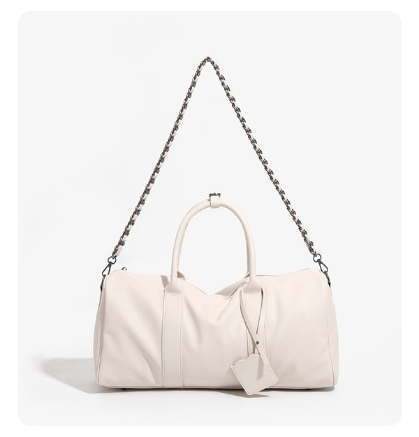 Large cream white pebbled leather-look barrel travel bag with twin top handles, chunky chain shoulder strap, front zip