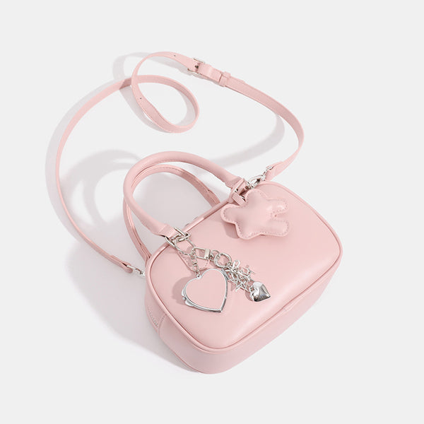 Small structured rounded-rectangle mini handbag with glossy leather-look finish, top zip closure, silver-tone hardware, and