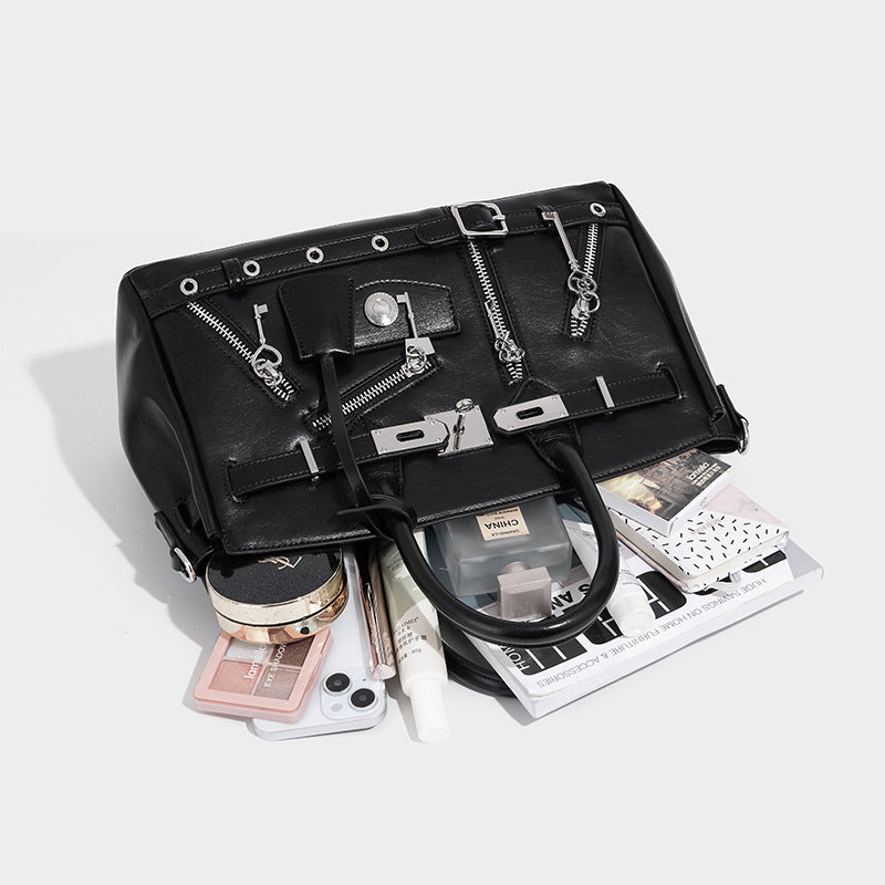 Structured black leather-look satchel bag with silver padlock hardware, front zip pockets, key charms, and top handles