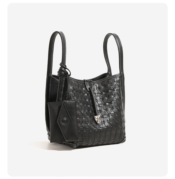 Cremefarbene Bucket Bag mit geometrischem Dreiecksrelief, schmalem Schulterriemen, goldfarbenem Dreiecksanhänger und abnehmbarer Mini-Tasche mit Druckknopfverschluss