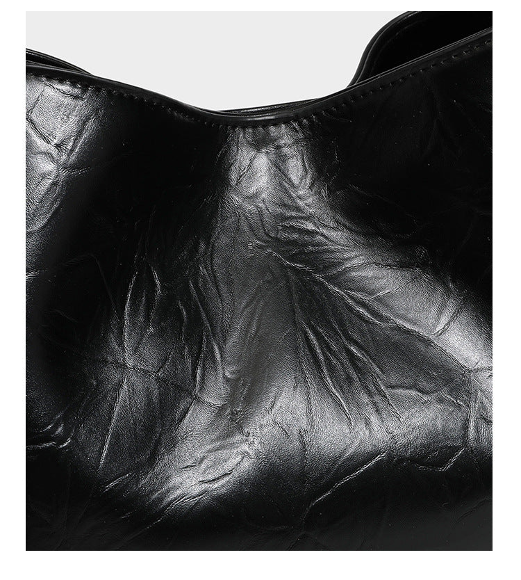 Black glossy crinkled leather-look convertible shoulder tote bag with gold gourd-shaped emblem hardware and detachable