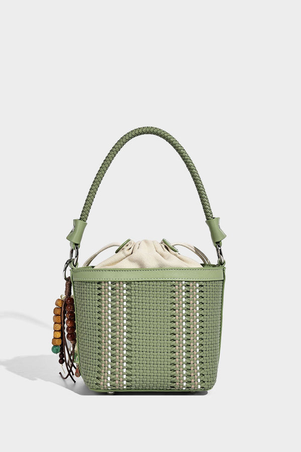 Small woven bucket bag with drawstring top, braided handle, detachable crossbody strap, and silver-tone ring hardware, detail