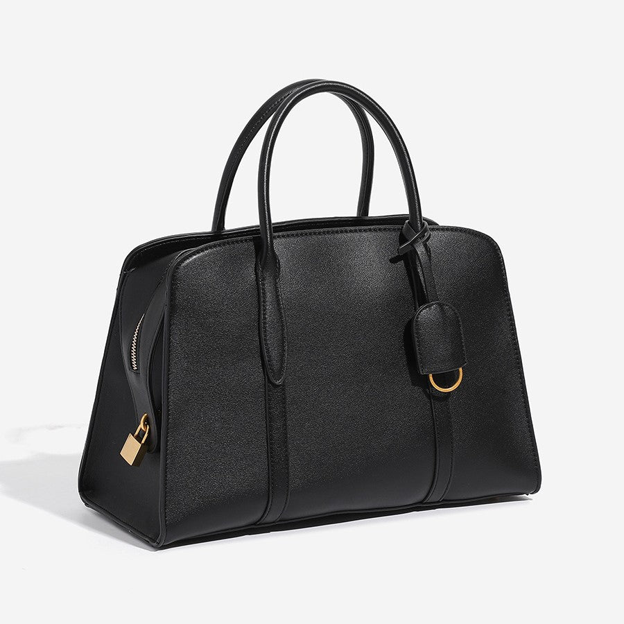 Structured trapezoid Boston satchel bag with dual top handles, gold-tone lock charm, and top zip closure, detail view 3