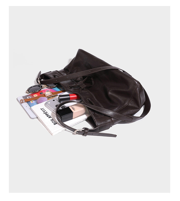 Lässig fallende Beuteltasche mit Kordelzug in dunkler Espresso-Lederoptik, verstellbarem Riemen und Ringbeschlägen aus Metall