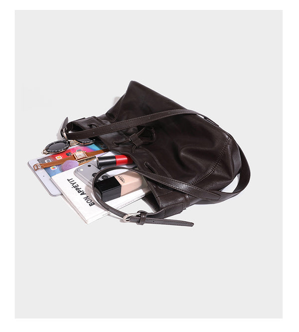 Lässig fallende Beuteltasche mit Kordelzug in dunkler Espresso-Lederoptik, verstellbarem Riemen und Ringbeschlägen aus Metall