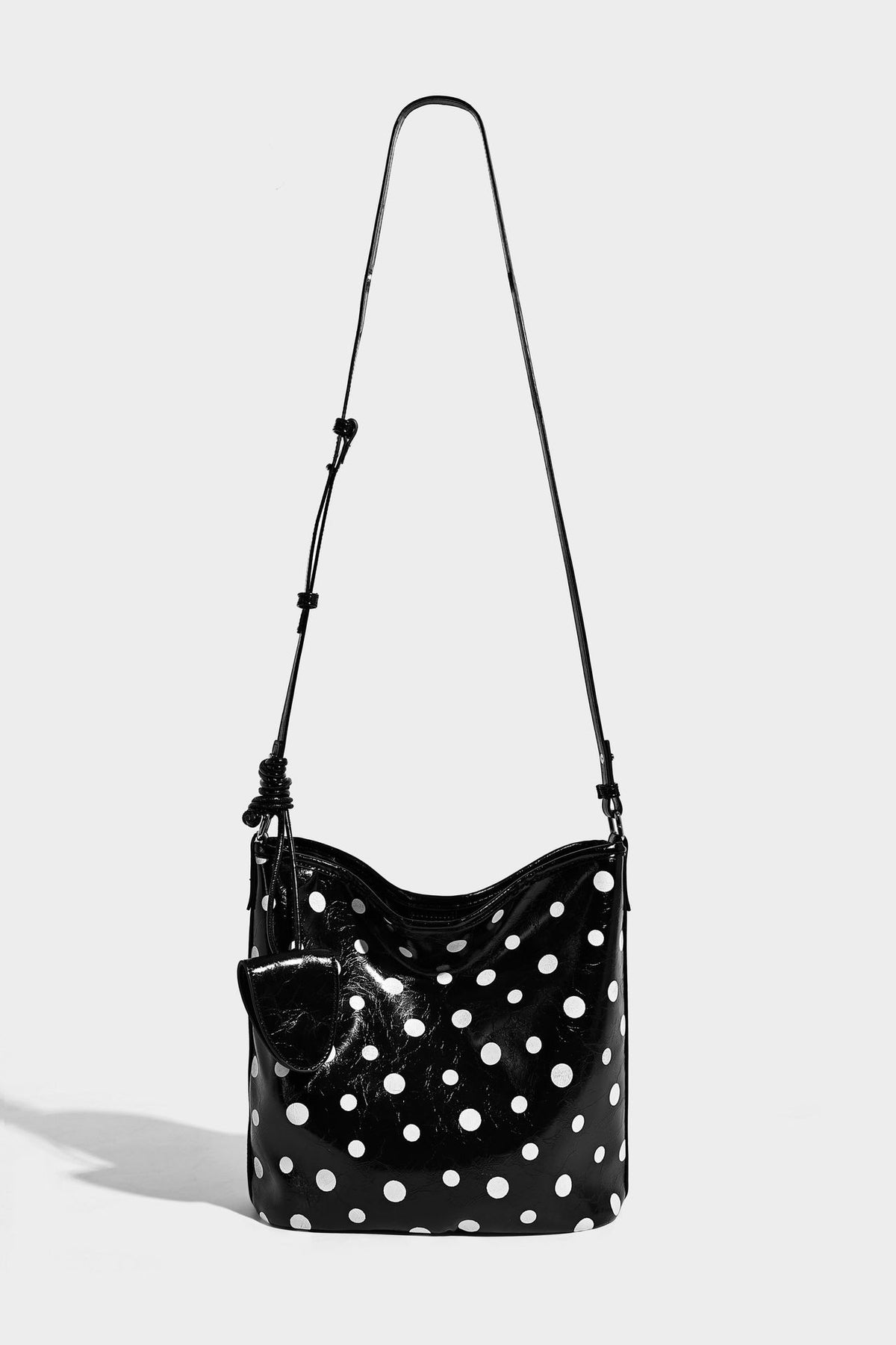 Glänzende Bucket-Bag mit schwarz-weißem Tupfenmuster, langem verstellbarem Riemen und Kordelzugverschluss, Detailansicht 19
