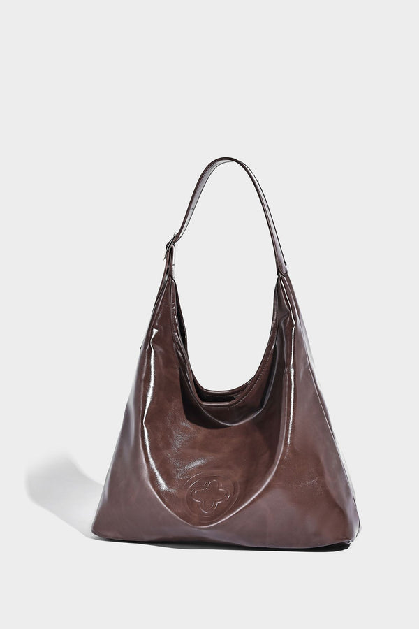 Glossy slouchy hobo shoulder bag with adjustable strap and embossed floral emblem, detail view 17