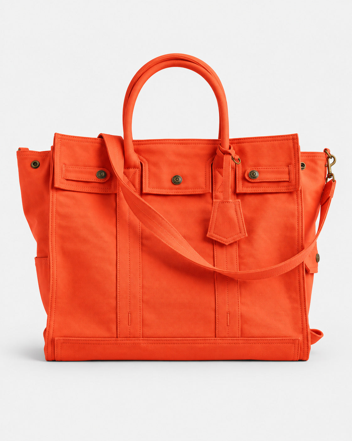 Large washed denim patchwork tote bag with snap-flap front pockets, rolled handles, and detachable shoulder strap, detail