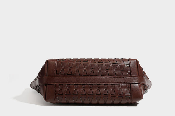 Large leather-look tote bag with geometric woven emboss, double shoulder straps, and round woven cord charm in brown, detail