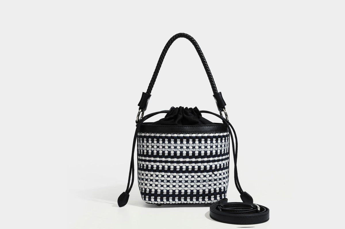 Small structured woven checker bucket bag with braided top handle, drawstring closure, and silver-tone hardware in black