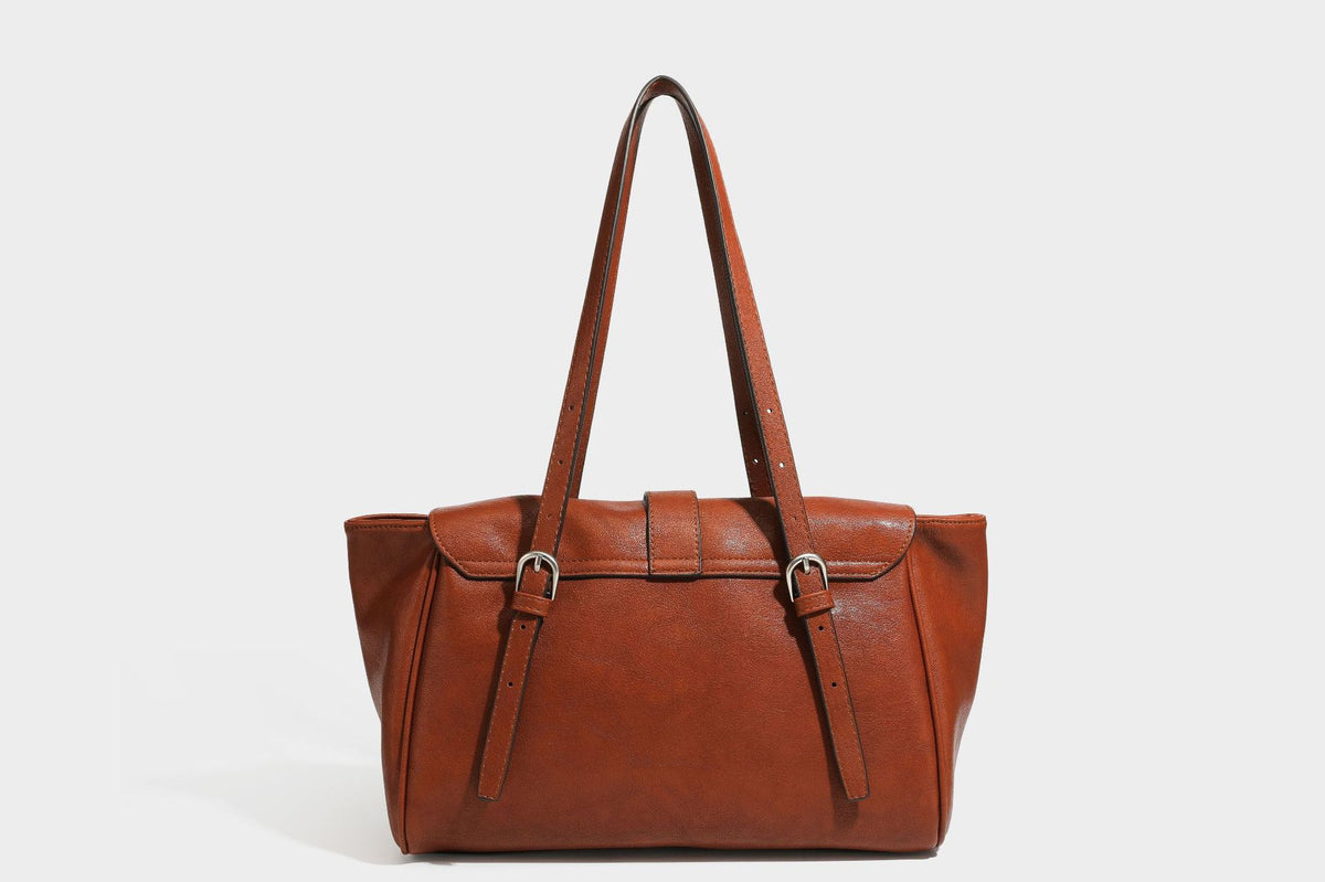 Large structured vintage-style tote bag with flap-front turn-lock closure, twin buckle straps, and double shoulder handles
