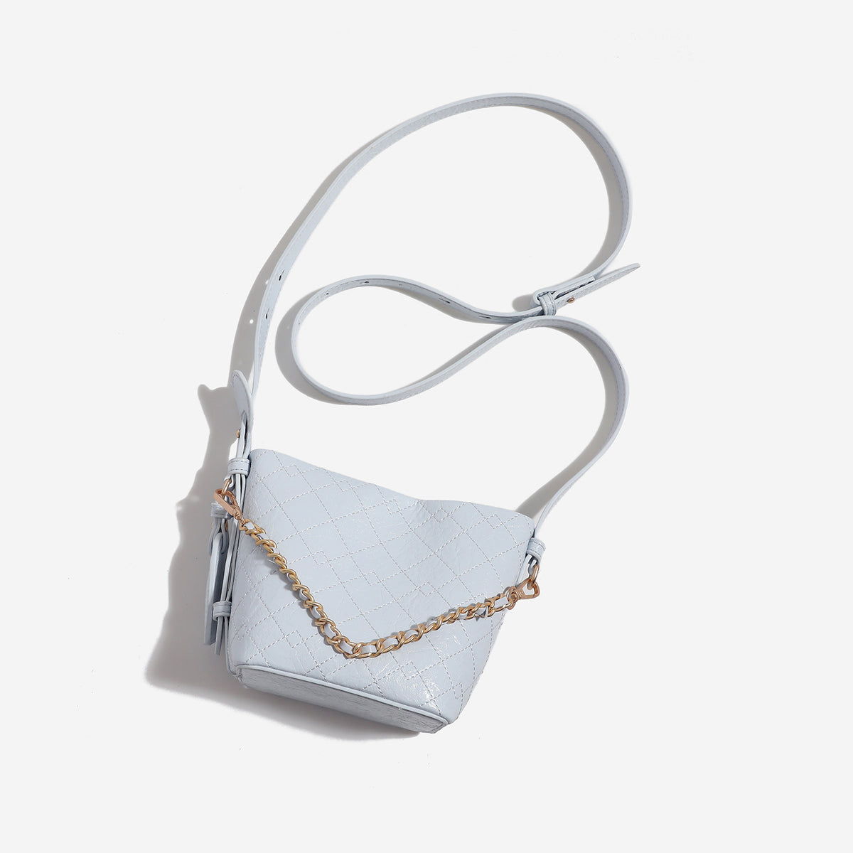 Small diamond-quilted bucket bag with gold-tone chain accent, heart strap detail, hanging tag, and matching zip coin pouch