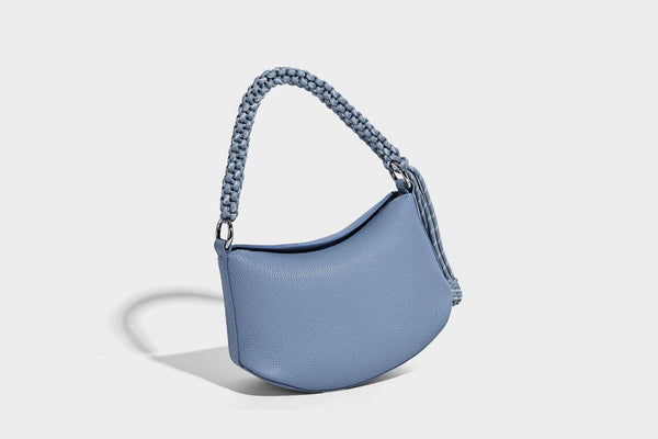 Small crescent half-moon bag in pebbled leather-look finish with braided top handle, silver-tone ring hardware, and, detail