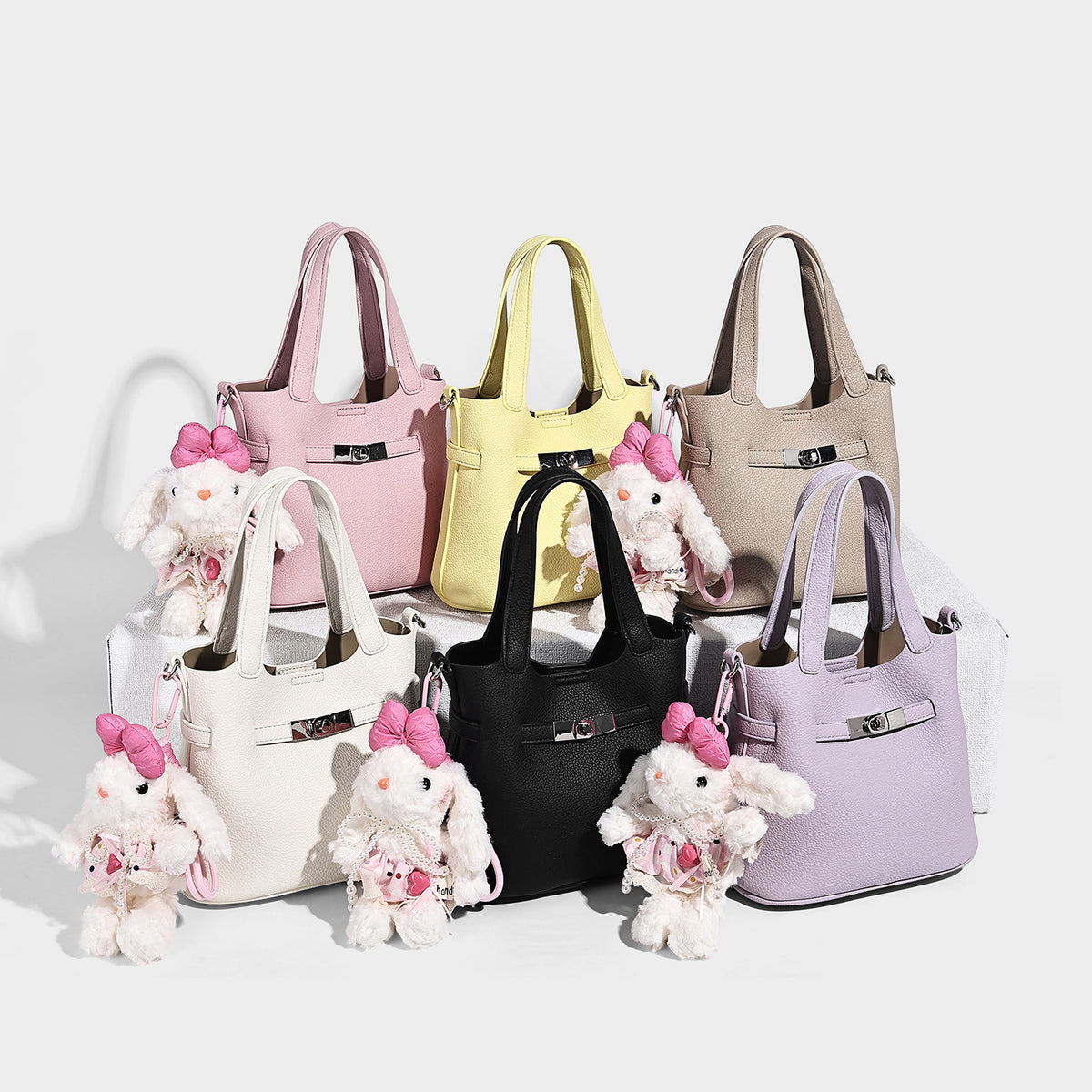 Small structured pebbled-finish tote bag with silver-tone turn-lock hardware and twin top handles, detail view 2