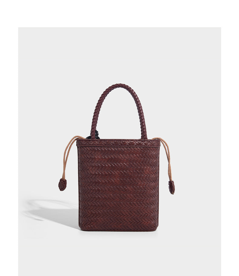 Small structured woven-texture tote bag with braided top handles and drawstring inner pouch, detail view 18