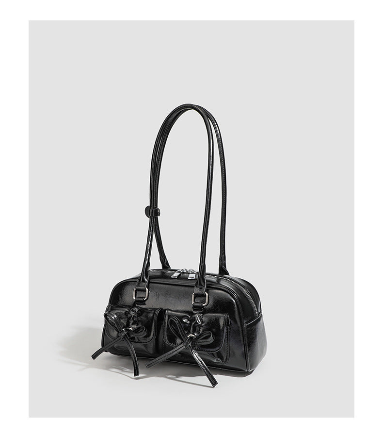 Kompakte glänzende Schultertasche aus Lederoptik mit vorderen Taschen mit Schleifen-Kordelzug, Reißverschluss oben, zwei Tragegriffen oben und Detail