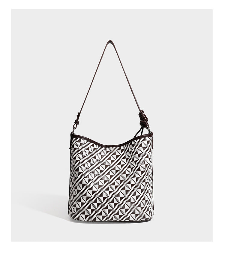 Geflochtene Schultertasche mit geometrischem Ethno-Muster, Besatz in dunkelbrauner Lederoptik, langem verstellbarem Träger und kleinem hängendem Reißverschluss