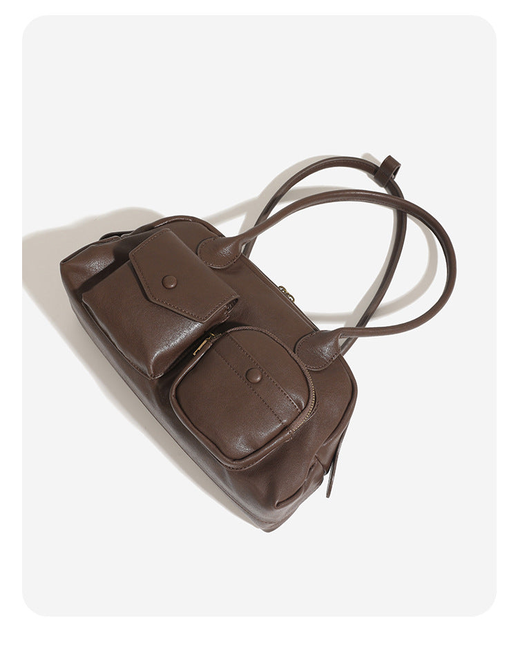 Structured retro bowling-style top-handle handbag with dual zip closure, front snap-flap pocket, and front zip pocket, detail