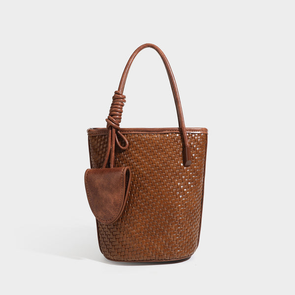 Structured woven-texture leather-look bucket bag in brown with knotted top handles, small front flap pouch, and adjustable
