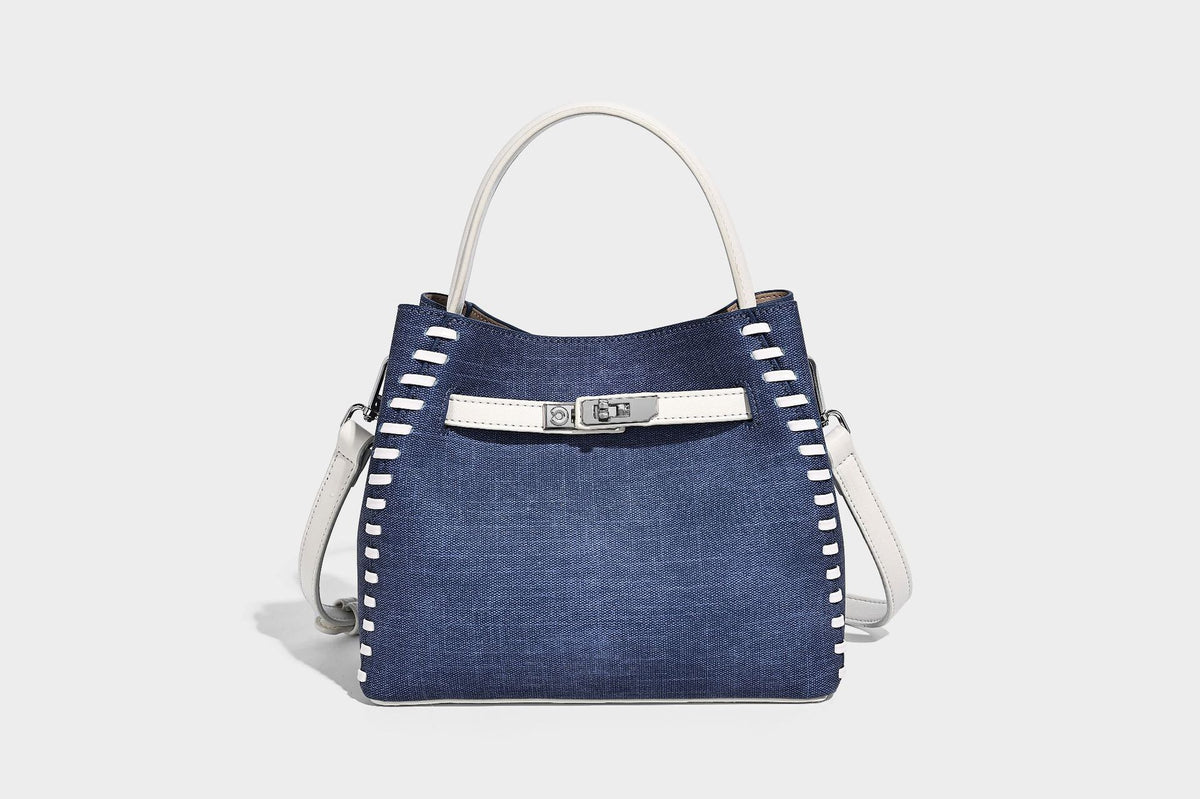 Formstabile Beuteltasche aus Denim mit weißem Zierstich-Besatz, silberfarbenem Drehverschluss, kurzen Henkeln und einem langen verstellbaren