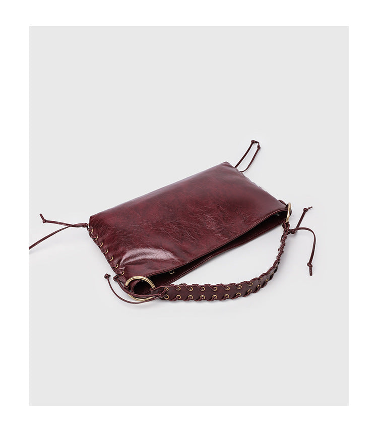 Large slouchy hobo shoulder bag with braided top handle, gold-tone O-ring hardware, and lace-up side cord detailing in