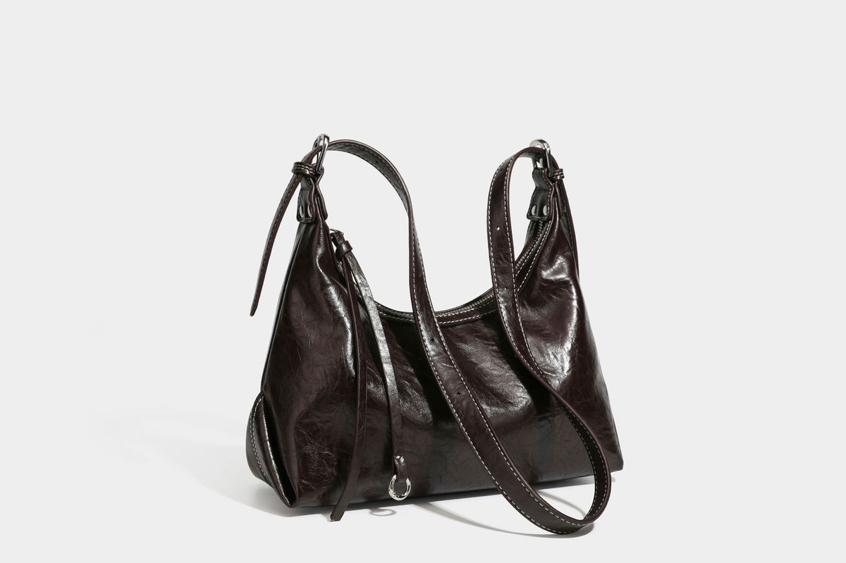 Slouchy hobo shoulder bag in glossy crinkled leather-look finish with zip-top closure and silver-tone ring hardware, detail