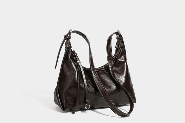 Slouchy hobo shoulder bag in glossy crinkled leather-look finish with zip-top closure and silver-tone ring hardware, detail