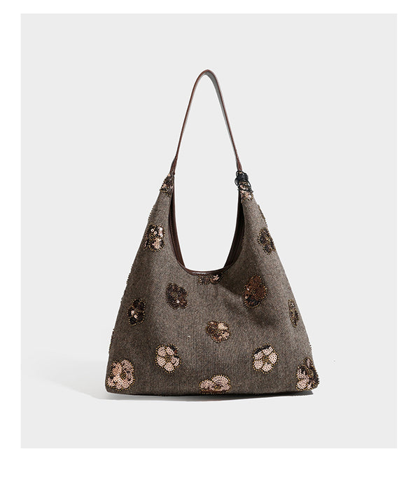 Lässig fallende, trapezförmige Schulter-Tote in Anthrazitgrau mit floralen Paillettenmotiven in Silber, Riemen in Lederoptik und herabhängendem Perlenbesatz