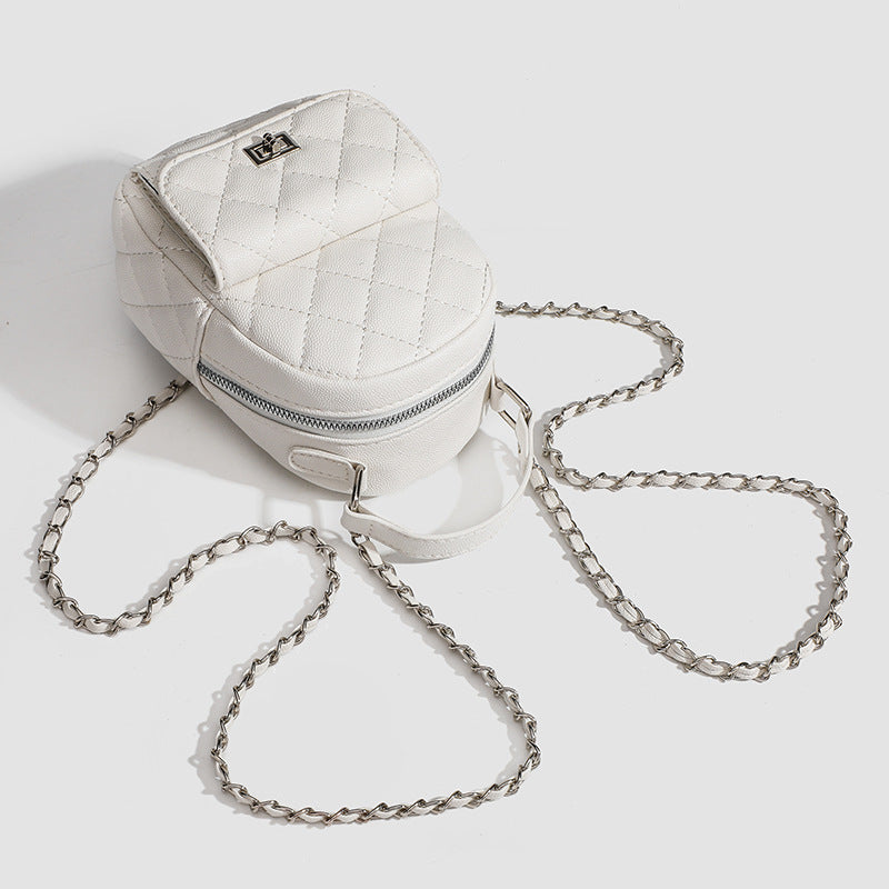 Compact diamond-quilted mini backpack handbag with silver-tone chain straps and turn-lock front pocket, detail view 4