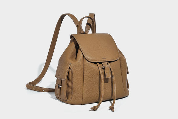 Compact pebbled leather-look flap drawstring backpack handbag with side pockets, top handle, and silver-tone hardware, detail