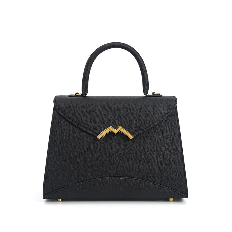 Structured trapezoid top-handle satchel in golden brown cross-grain textured finish with gold M-shaped clasp hardware and