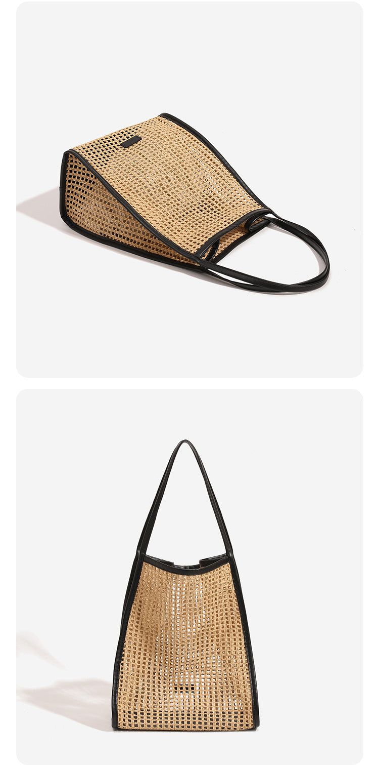 Tan open-weave raffia tote bag with black leather-look trim and long black shoulder straps, trapezoid silhouette, detail view