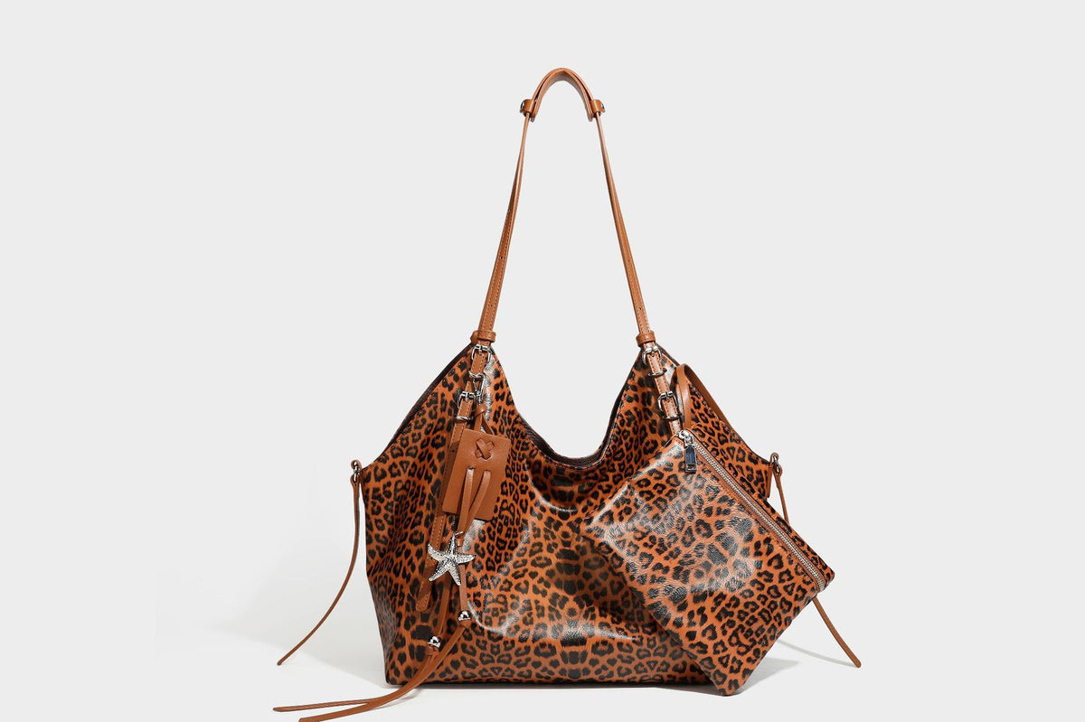 Large leopard print shoulder tote bag with glossy finish, long double straps, front zip pocket, silver-tone hardware, and