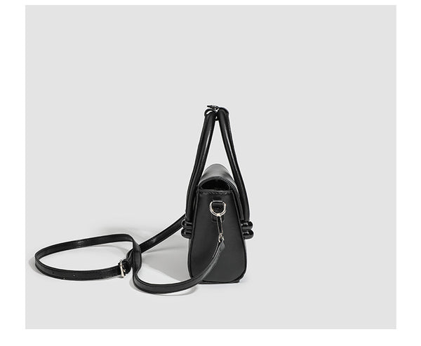 Kleine, strukturierte Henkeltasche in schwarzer Lederoptik mit zwei abgerundeten Henkeln, abnehmbarem Umhängeriemen und silberfarbenem