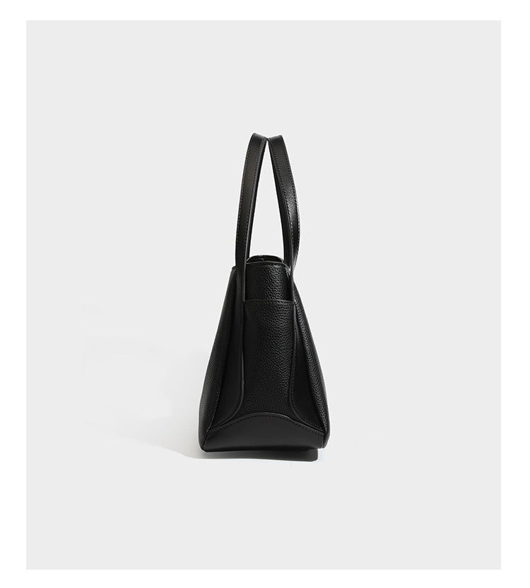 Schwarze Tote-Bag aus genarbtem Material in Lederoptik mit kürbisförmigen Beschlägen in Goldoptik, zwei Henkeln und abnehmbarem Umhängeriemen, Detailansicht