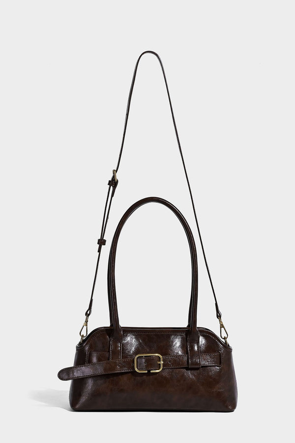 Strukturierte dunkelbraune Henkeltasche mit Öl-Wachs-Finish, vorderer Gürtelschnalle, goldfarbenen Beschlägen und zwei Tragegriffen, Detailansicht