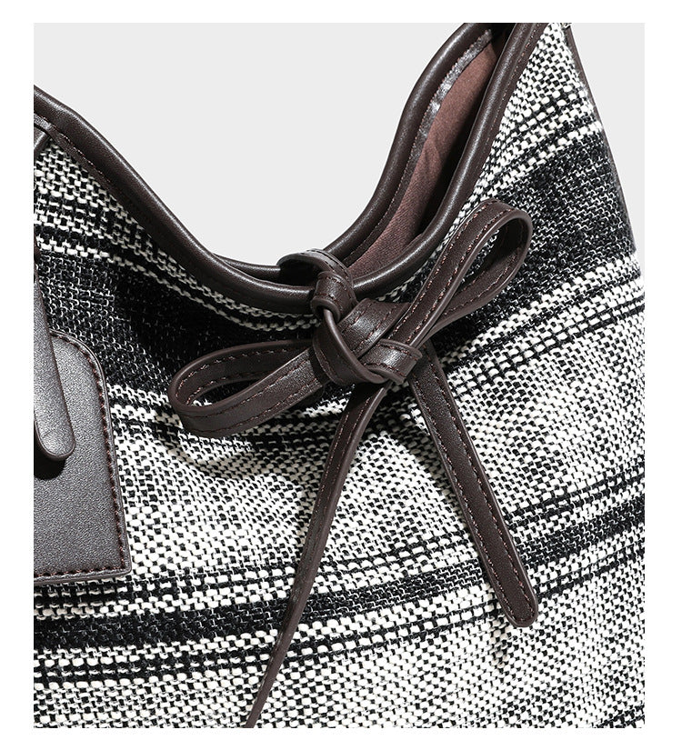 Schwarz-weiße karierte Hobo-Schultertasche mit dunkelbraunen Besätzen in Lederoptik, Kordelzugverschluss und langem, verstellbarem