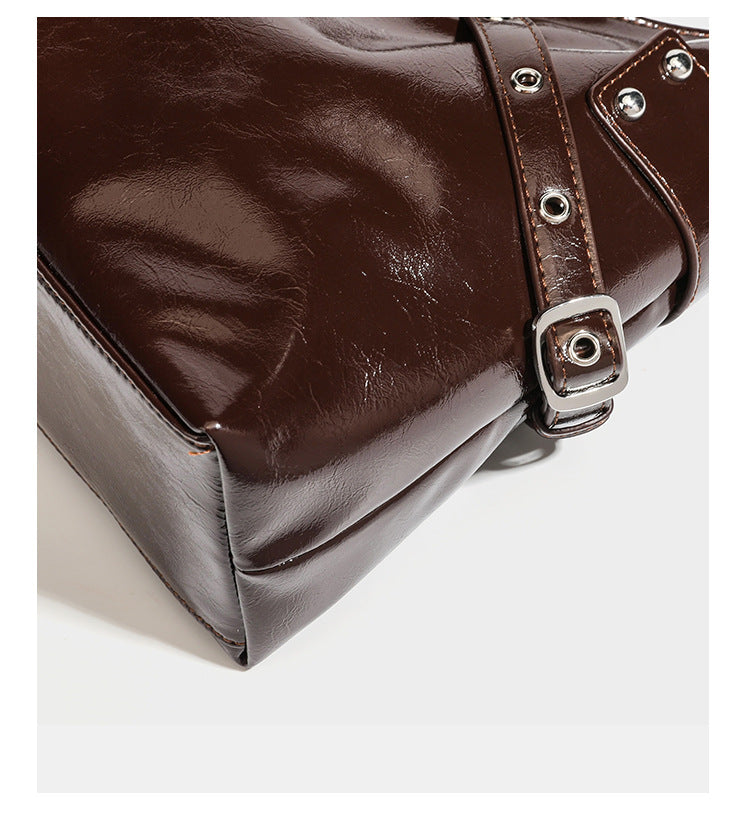 Glänzende dunkelbraune, lässig geschnittene Hobo-Schultertasche mit Riemendetail mit silberfarbenen Ösen, Reißverschlussfach auf der Vorderseite und Herz mit Leopardenmuster