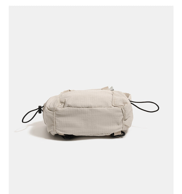 Mini rounded convertible backpack handbag in matte ripstop fabric with dual top handles, adjustable straps, and side, detail